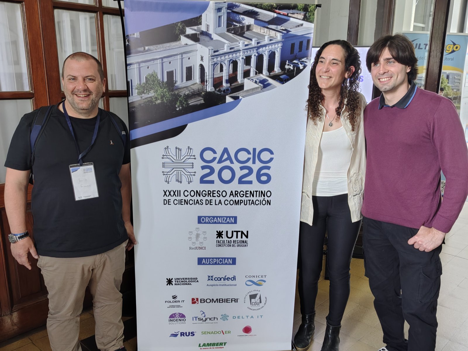 Integrantes del LICDIA junto al banner del XXXII Congreso Argentino de Ciencias de la Computación (CACIC 2026)